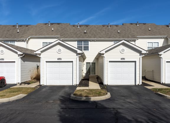 a row of houses with white roofs and garages at Traditions at Slate Ridge, Reynoldsburg