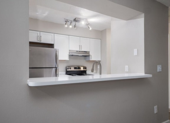 a kitchen with white cabinets and a sink and a refrigerator at The Berryessa Apartments, Ohio, 98104