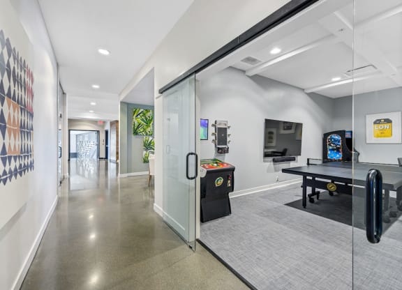 Two-Bedroom Apartments in West Chester, OH - Liberty Center - Gameroom with Ping Pong Table, Arcade Games, and a Mounted Television