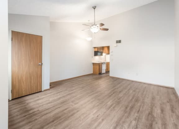 an empty living room and kitchen with wood flooring and a ceiling fan at Parkside at Maple Canyon Apartments, Columbus, 43229