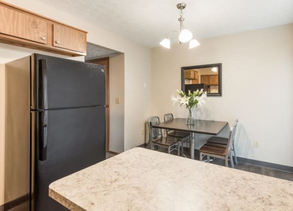 a kitchen and dining room with a black refrigerator and a table and chairs at Parkside at Maple Canyon Apartments, Columbus, 43229