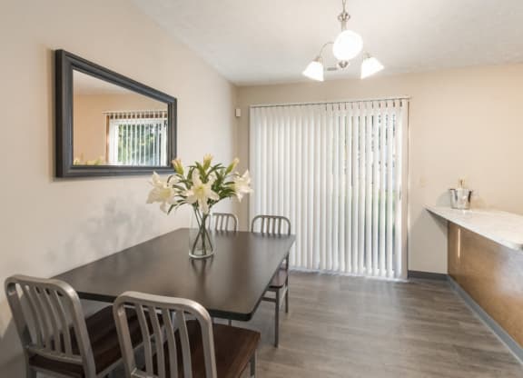 a dining room with a table and chairs and a window at Parkside at Maple Canyon Apartments, Columbus, OH