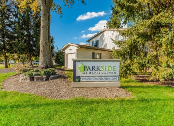a parkide sign in front of a house with trees at Parkside at Maple Canyon Apartments, Columbus
