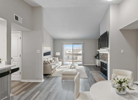 A living room with a white couch and a television on the wall.