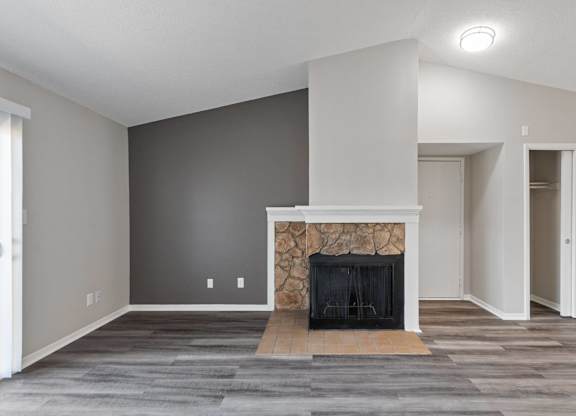 A modern living room with a fireplace and grey carpet.