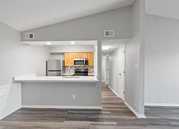 A kitchen with a white countertop and a wooden cabinet.