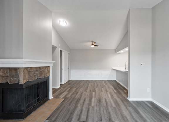 A room with a fireplace and wood flooring.