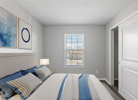 A bedroom with a large bed and a window overlooking a building.