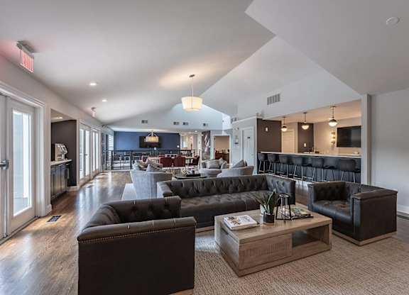 A living room with a black couch and a coffee table.