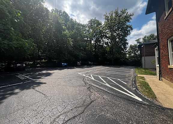 a parking lot with a building and trees at Cincinnati Premier Living*, Cincinnati