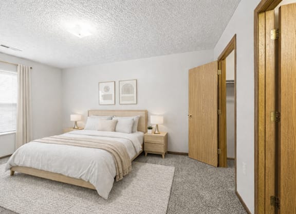 A bedroom with a large bed and two nightstands.