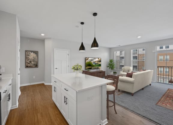 an open kitchen and living room with white cabinets and a white counter top at Monmouth Row Apartments, Newport, KY, 41071