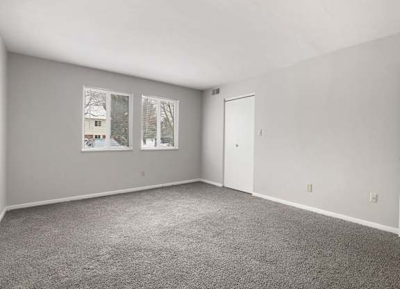 A room with grey carpet and white walls.