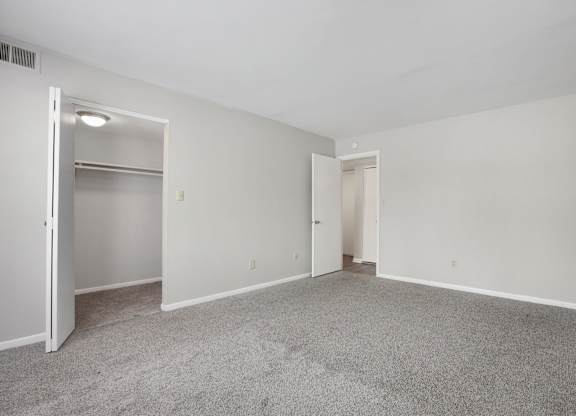 A room with a grey carpet and white walls.