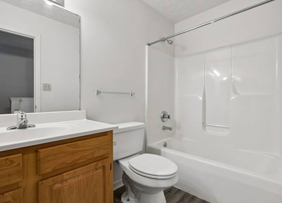 A white bathroom with a toilet, sink, and bathtub.