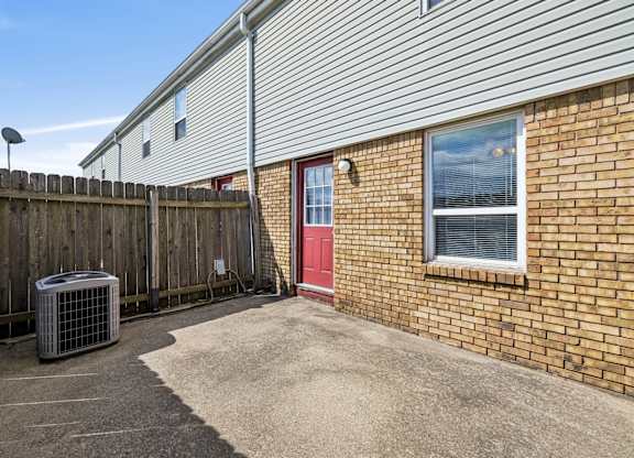 A red door is on the brick house. at Sharon Green Townhomes, Ohio