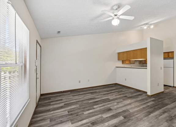 A room with a ceiling fan and a window with blinds.