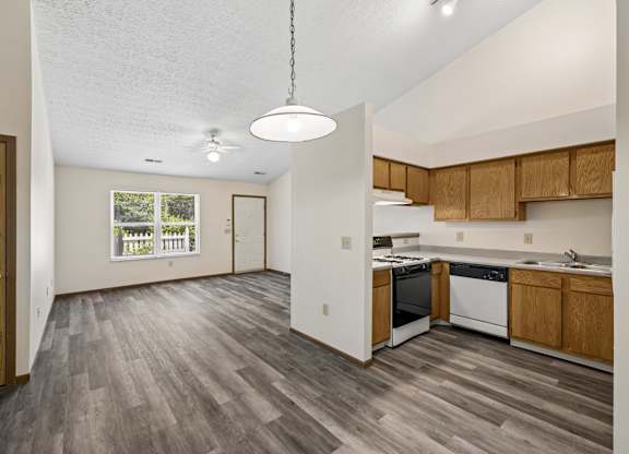 A kitchen with wooden cabinets and a grey floor.