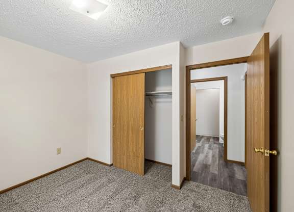 A room with a carpeted floor and a wooden door.