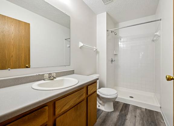 A bathroom with a toilet, sink, and shower.