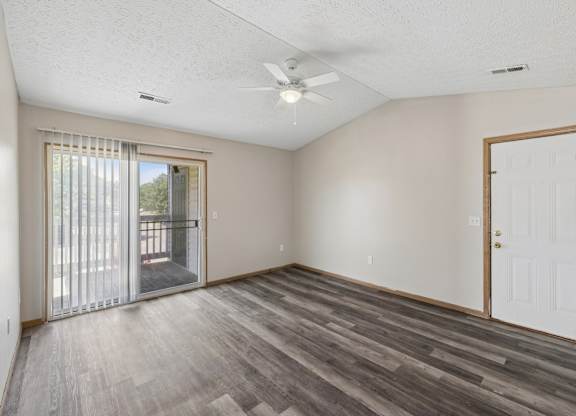A room with a sliding glass door and a white door.