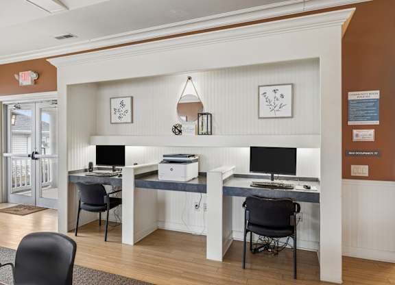 A white desk with a computer and printer on it.
