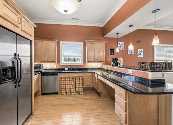 A kitchen with wooden cabinets and a black refrigerator.