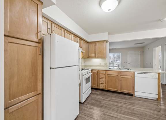 A kitchen with wooden cabinets and a white refrigerator.