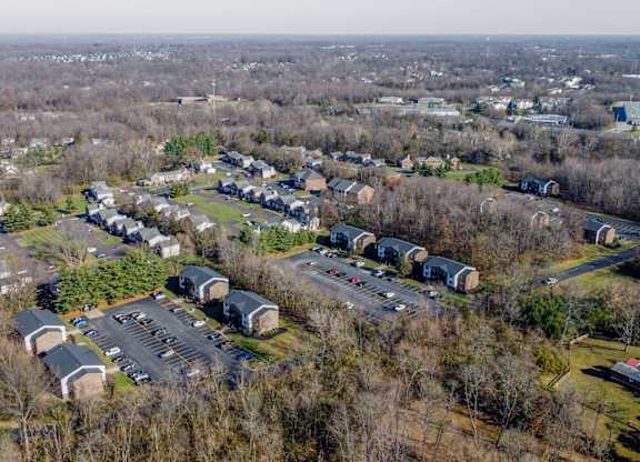 A bird's eye view of a parking lot surrounded by buildings and trees.