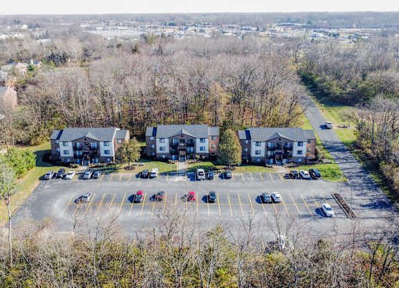 A parking lot with several cars and a building in the background.