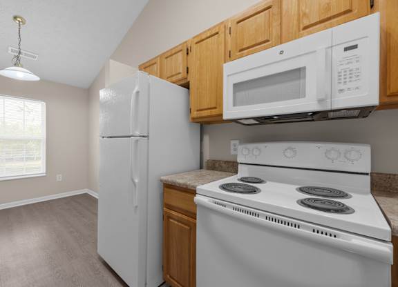 A kitchen with a white stove and a white refrigerator.