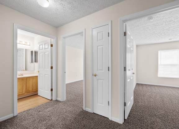 A room with white doors and a carpeted floor.