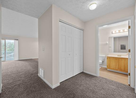 A large, empty room with a carpeted floor and white walls.