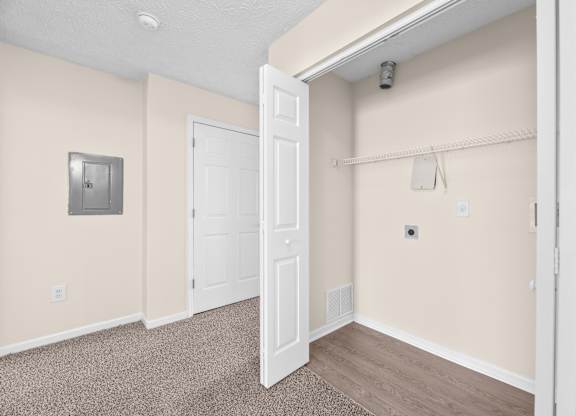A room with a white door and a white wall with a light switch.