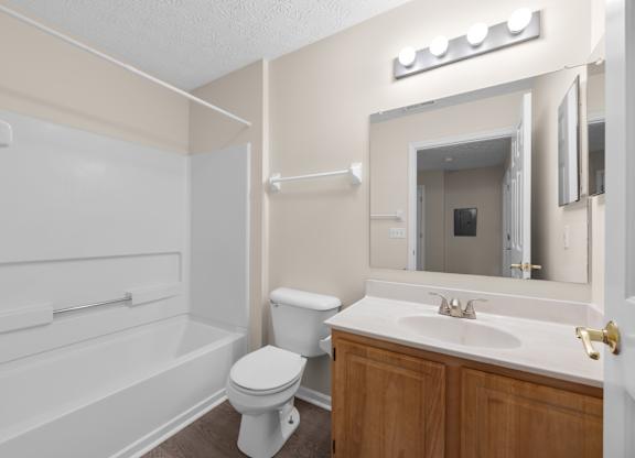 A white toilet sits in a bathroom next to a white sink.
