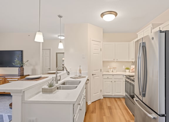 a kitchen with white cabinets and stainless steel appliances at Roebling Row, Kentucky