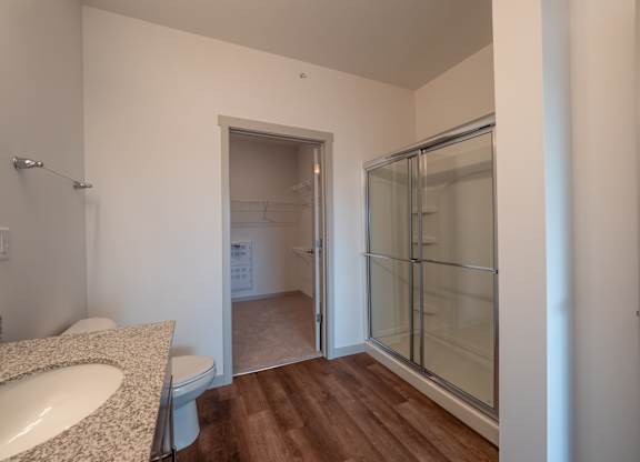 A bathroom with a sink, toilet, and shower.at The Row on Merchant Apartments, Ohio, 45246