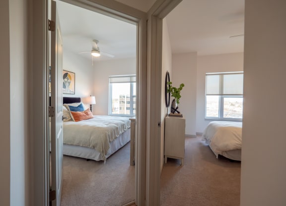 a bedroom with two beds and a closet at The Row on Merchant Apartments, Springdale, OH