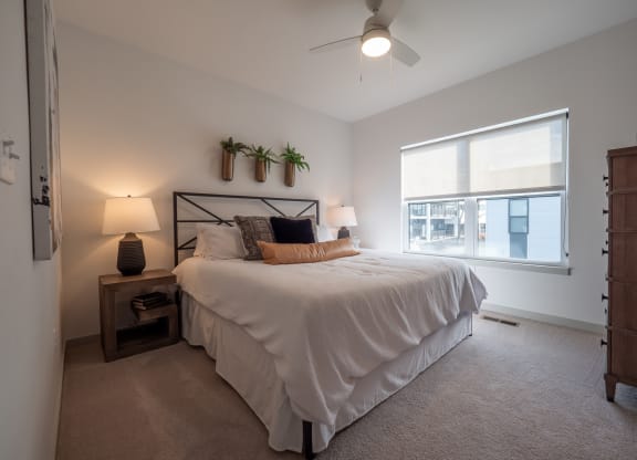 a bedroom with a large white bed and a window at The Row on Merchant Apartments, Springdale, OH, 45246
