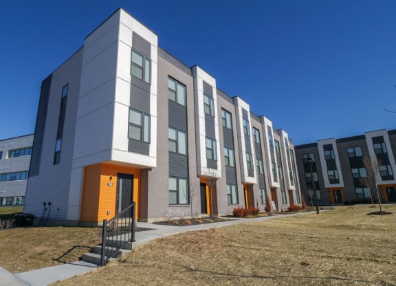 a row of new apartment buildings on a sunny day at The Row on Merchant Apartments, Springdale, OH, 45246