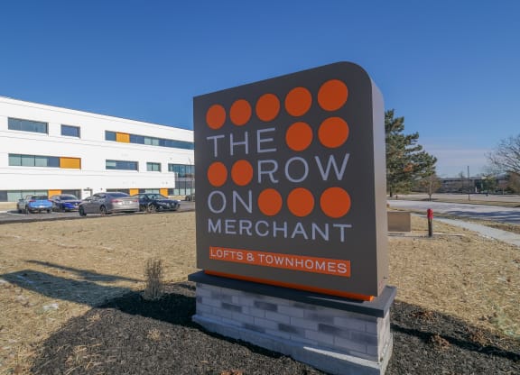 a sign that reads the row on merchant in front of a building at The Row on Merchant Apartments, Springdale, Ohio