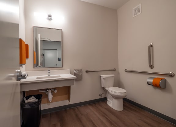 a bathroom with a sink and a toilet and a mirror at The Row on Merchant Apartments, Springdale, OH