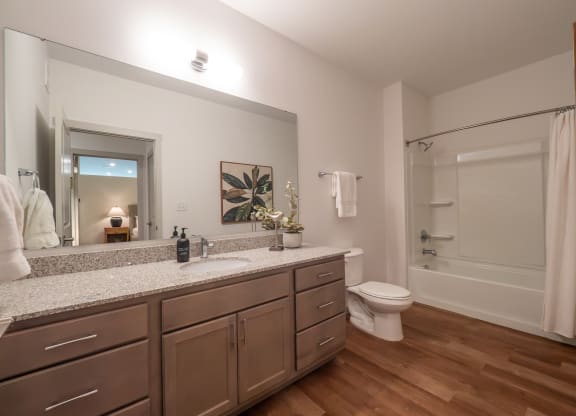 a bathroom with a large mirror and a sink and a toilet at The Row on Merchant Apartments, Ohio