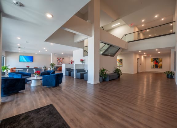 a large lobby with couches and chairs and a staircase at The Row on Merchant Apartments, Ohio