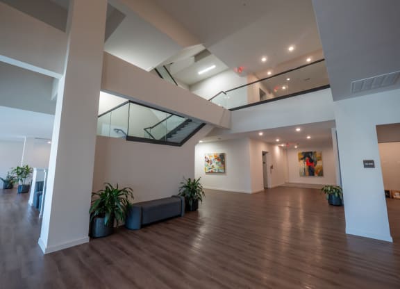 a large room with a wood floor and a staircase at The Row on Merchant Apartments, Springdale, 45246
