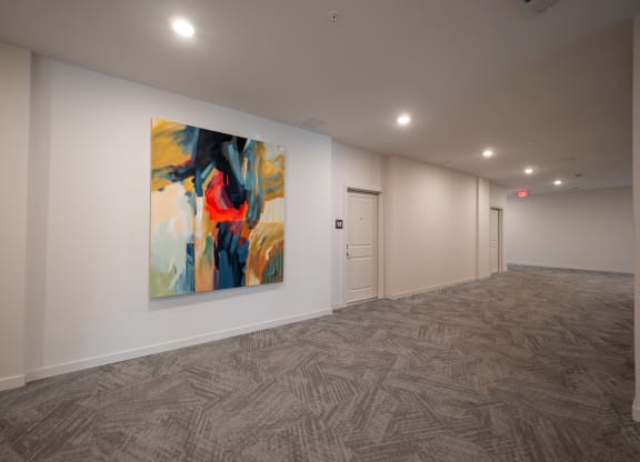 a room with a painting on the wall and a hallway with a door at The Row on Merchant Apartments, Ohio, 45246