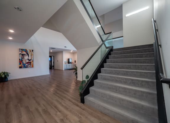 a staircase with a glass railing and a wooden floor in a house at The Row on Merchant Apartments, Springdale