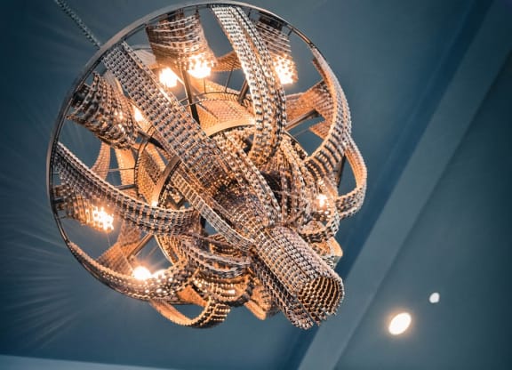 a chandelier hanging from a blue ceiling with a glass window