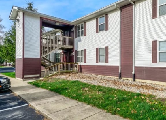 a white and brown apartment building with a sidewalk in front of it at Ridgeview, Indiana, 46040