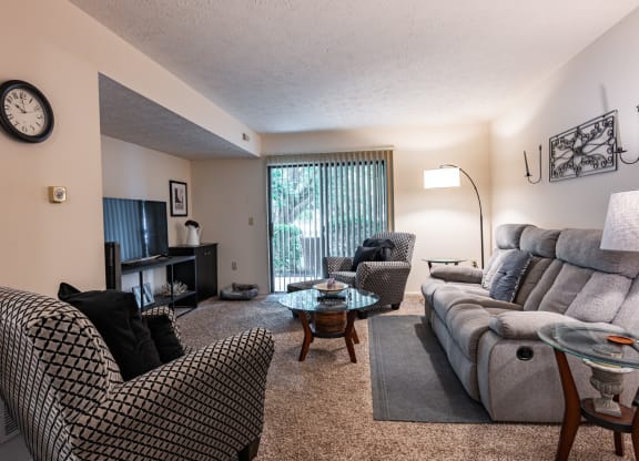 an open living room with a couch and chairs and a tv